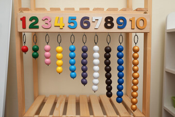 Montessori toy with color bead lines and numbers on wooden stand indoors - obrazy, fototapety, plakaty