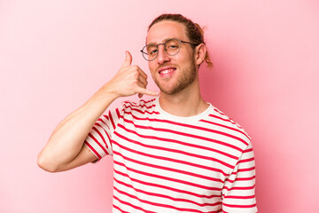 Fototapeta premium Young caucasian man isolated on pink background showing a mobile phone call gesture with fingers.