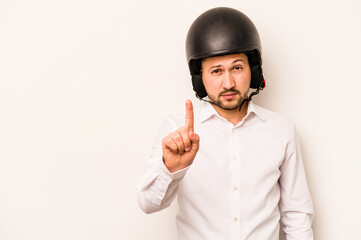 Hispanic business man going to work with motorcycle isolated on white background showing number one with finger.