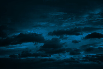 Dark blue green sky with clouds. Dramatic night sky. Moonlight. Toned background with space for design.