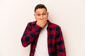 Fototapeta premium Young hispanic man isolated on white background covering mouth with hands looking worried.