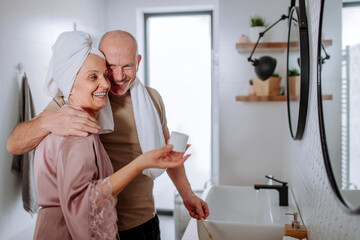 Senior couple in love in bathroom, brushing teeth and hugging, morning routine concept.