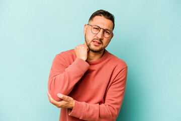 Young hispanic man isolated on blue background massaging elbow, suffering after a bad movement.