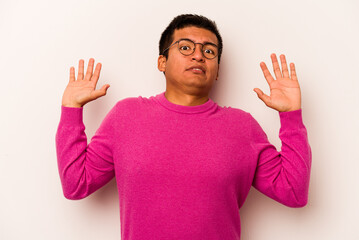 Young hispanic man isolated on white background being shocked due to an imminent danger