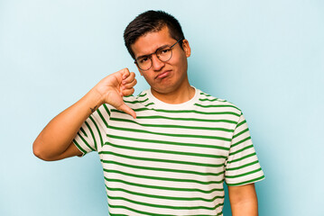 Young hispanic man isolated on blue background showing thumb down, disappointment concept.