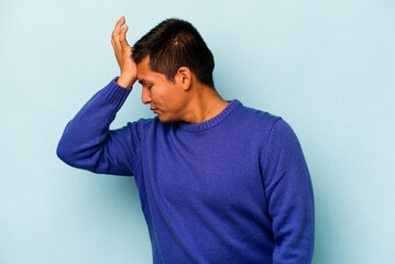 Young hispanic man isolated on blue background forgetting something, slapping forehead with palm and closing eyes.