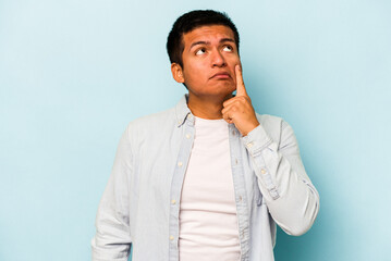 Young hispanic man isolated on blue background crying, unhappy with something, agony and confusion concept.