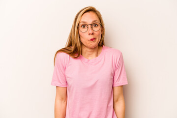 Young caucasian woman isolated on white background shrugs shoulders and open eyes confused.