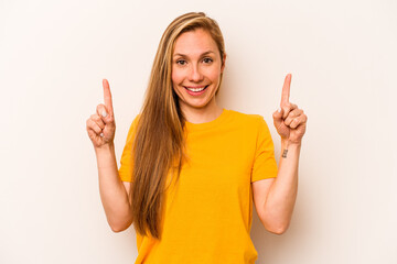 Young caucasian woman isolated on white background indicates with both fore fingers up showing a...