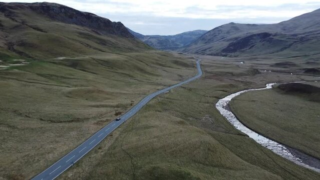 A sport car in Scotland highlands near Glenshee against a backdrop of wilderness
