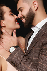 Handsome bearded man with sexy lady on black background, closeup