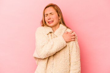 Young caucasian woman isolated on pink background having a shoulder pain.