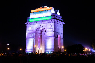 Night view of India gate with Indian flag lighted on it.
