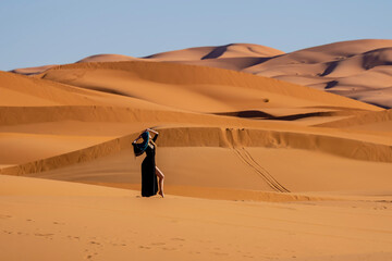 A Beautiful Model Poses In The Sand Dunes In The Great Sahara Desert In Morocco, Africa