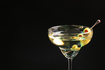 Martini cocktail with olives on dark background, closeup. Space for text