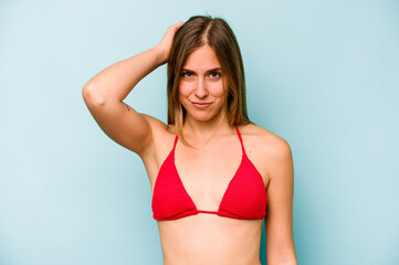Fototapeta premium Young caucasian woman going to the beach isolated on blue background being shocked, she has remembered important meeting.