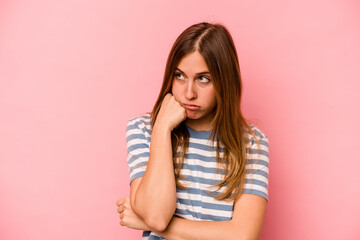 Young caucasian woman isolated on pink background tired of a repetitive task.