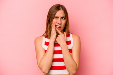 Young caucasian woman isolated on pink background having a strong teeth pain, molar ache.
