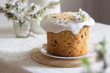 Traditional easter cake or sweet bread, apple brahces in bloom on white plate on light linen tablecloth. Side view, selective focus. Easter treat, holiday symbol