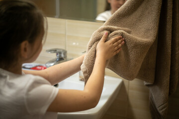 Dziecko wycierające ręce po umyciu w łazience - obrazy, fototapety, plakaty