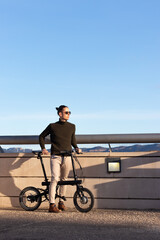 Naklejka premium Young handsome man riding an electric bicycle as a sustainable and eco friendly alternative to go around the city