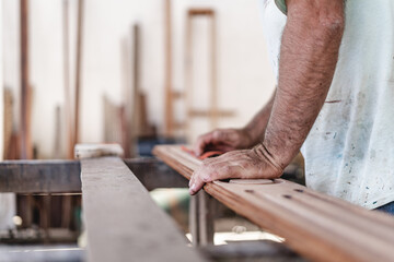 Unknown carpenter sanding a piece of wood.