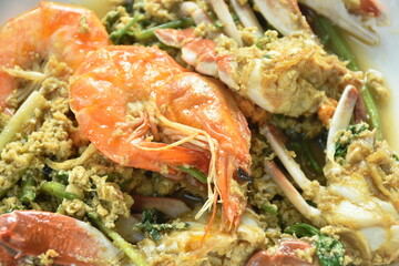stir fried swimmer crab and shrimp in yellow curry with egg on plate
