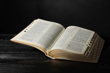 Open Bible on black wooden table. Christian religious book