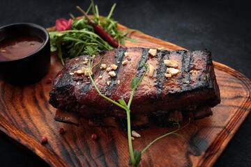 Grilled ribs with sauce on a wooden board