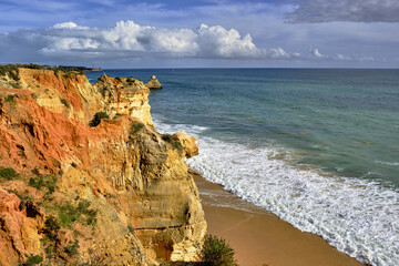 golden cliff and rocks on Praia do Amado beach in Portimao, Algarve, Portugal