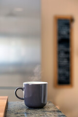 coffee cup on countertop in kitchen with blurry background