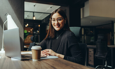 Cheerful young businesswoman working in a coworking office