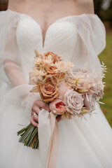 The bride holds a beautiful bouquet of white flowers. Close-up view