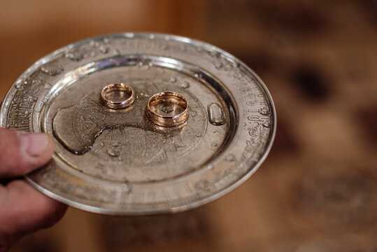 A silver tray with wedding rings at the church