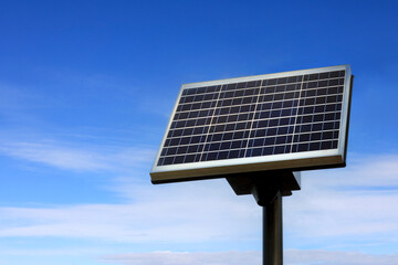 Small Solar Panel against Blue Sky and Some White Clouds on a Beautiful day, Copy Space Left of...