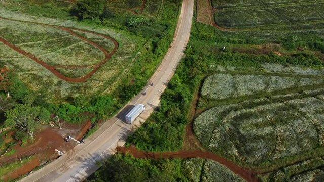 Aerial shot of Delivery truck on a Country Road and Large Plantation