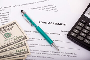 Mortgage. The pen, money and calculator are on the loan agreement