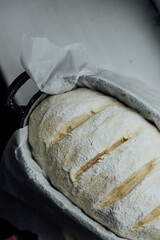 Loaf of proofing bread, raw dough in a proofing bowl, homemade wild yeast bread.