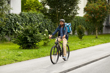 food shipping, transportation and people concept - happy smiling delivery man in bike helmet with...