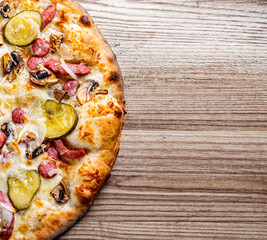 Pizza with cheese, salami, chicken meat, beef, ham, Tomato sauce, pepper, spices. Italian pizza on wooden background