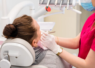 Dentist girl conducts an examination of the client. Close-up