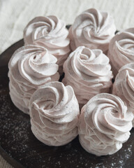 Homemade russian marshmallow - zephyr on brown wooden plate on a light table, selective focus