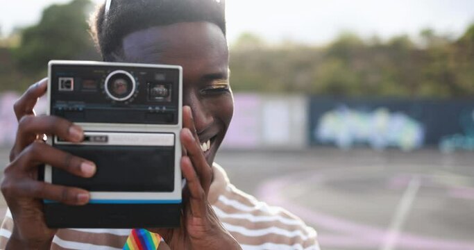 Young african man using vintage old camera outdoor