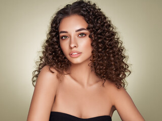 Fashion studio portrait of beautiful smiling woman with afro curls hairstyle. Fashion and beauty