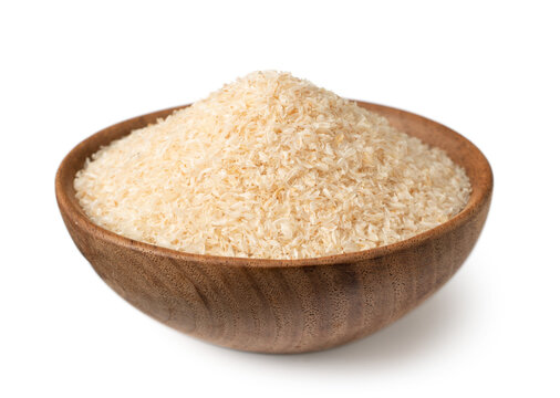 Psyllium husks in the wooden bowl, isolated on white background.