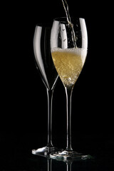 two glasses of champagne on black