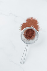 Cocoa powder sweet ingredient in a strainer