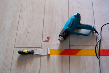 heat gun and spatula for removing marker tape from ground