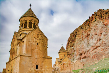 Fototapeta na wymiar Church surrounded by red rocks. Amazing nature with unique colorful mountains and Noravank Monastery