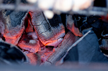 The hot embers of burning wood log fire. Firewood burning on grill. Abstract background. Selective...